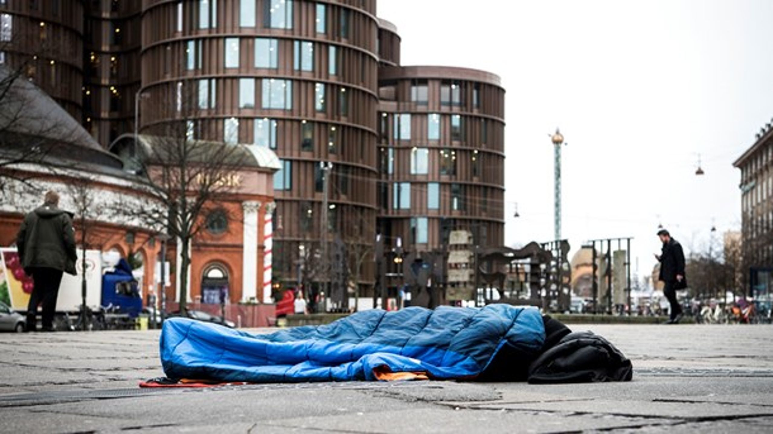 Hjemløs mand sover på Axeltorv i København.
