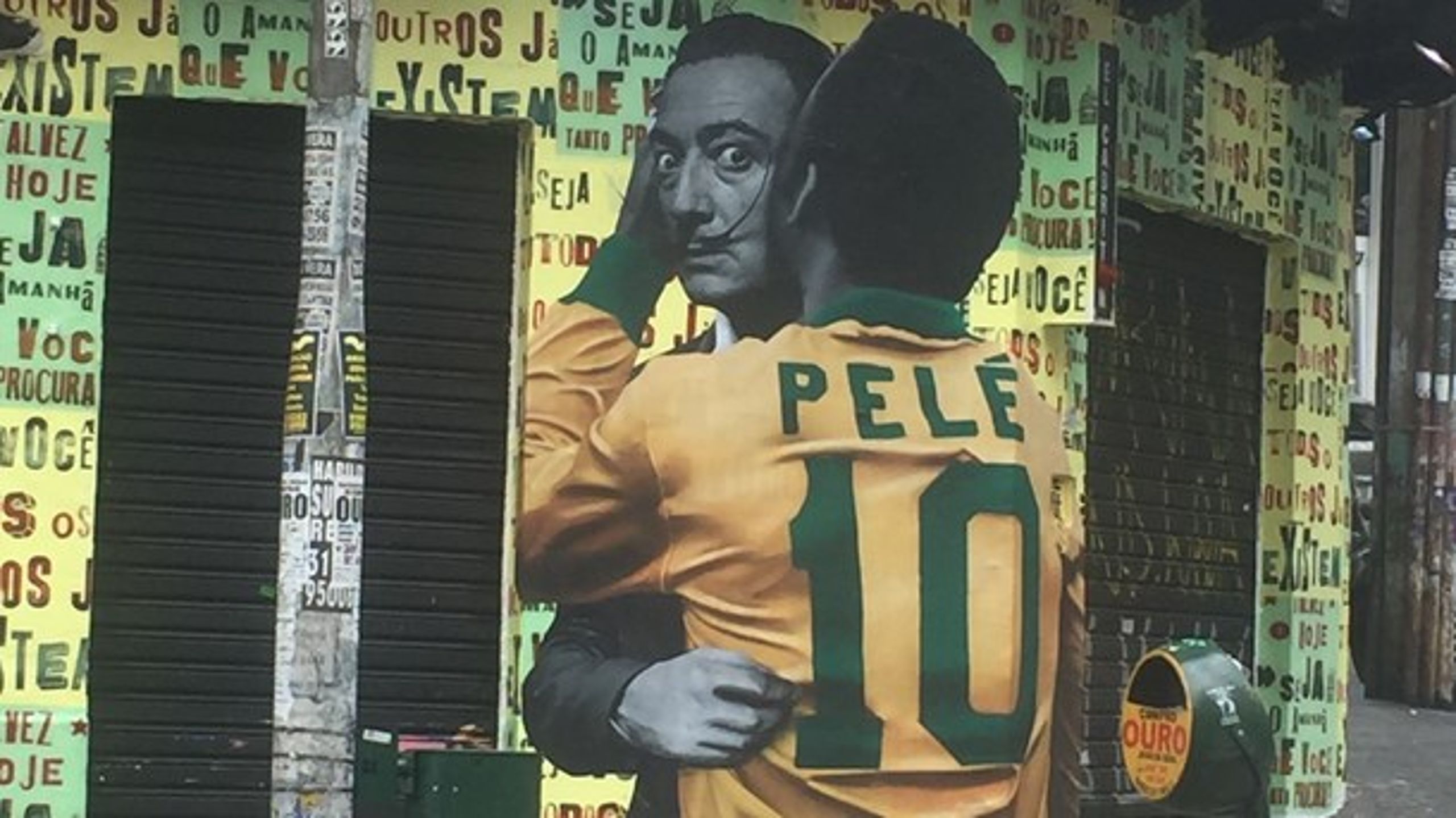 I Brasilien fylder&nbsp;VM i fodbold meget i gadebilledet. Her er det den afdøde spanske surrealist Salvador Dali, der omfavner fodboldlegenden over dem alle, brasilianske Pelé. Foto:&nbsp;Tina Gottlieb.