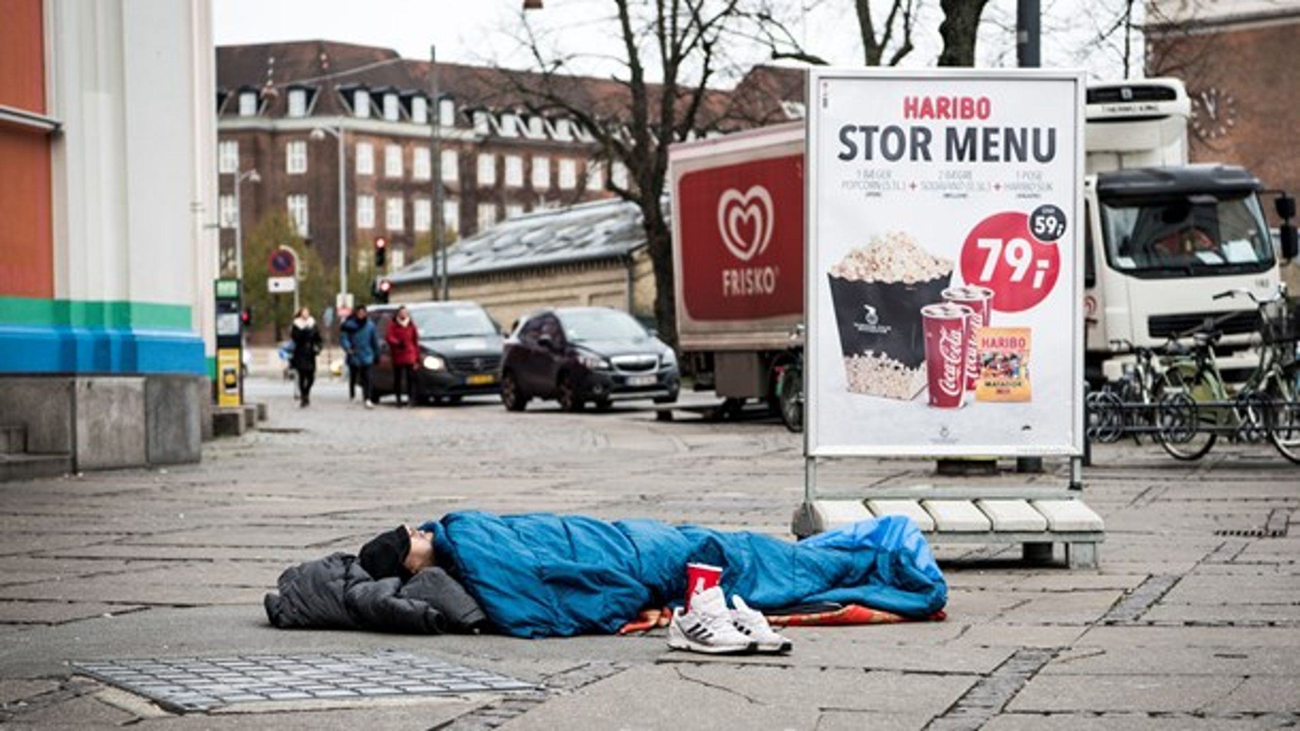 Hjemløs mand sover på Axeltorv, København.