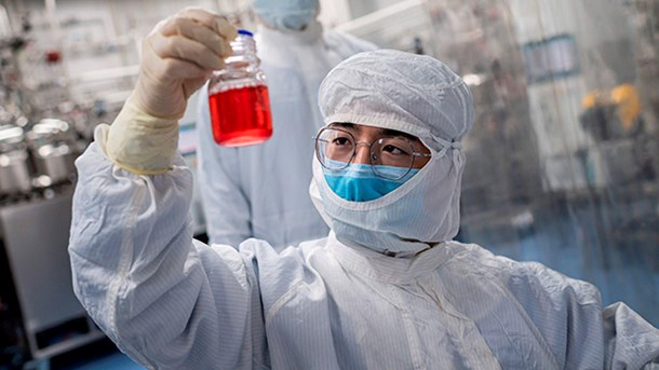 Kinesisk forsker stirrer på abenyre-celler i en test af vaccine mod covid-19.